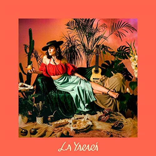 Woman in red top and green skirt lounges surrounded by tropical plants on album cover.
