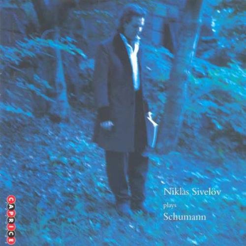 "CD cover with a man in a coat standing in a forest."