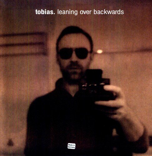 Vinyl album cover with man taking selfie, wearing sunglasses, in a dimly lit room.