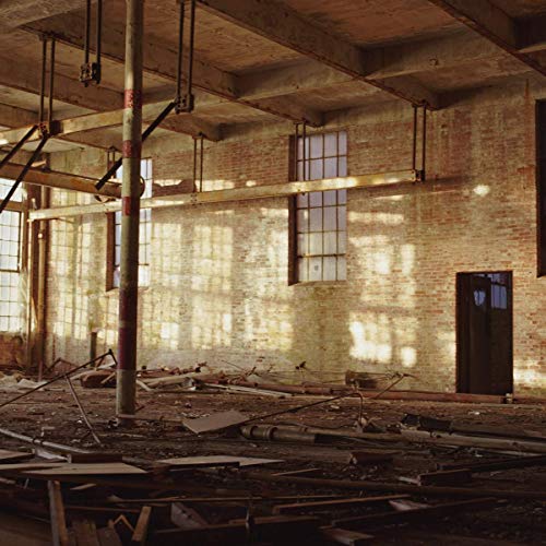 The image depicts an abandoned industrial space with exposed brick and debris. For the product "Katie Gately - Loom [VINYL]" with EAN: 5065000444273, a concise alt text could be: "Abandoned industrial room with exposed brick, debris, and metal poles."