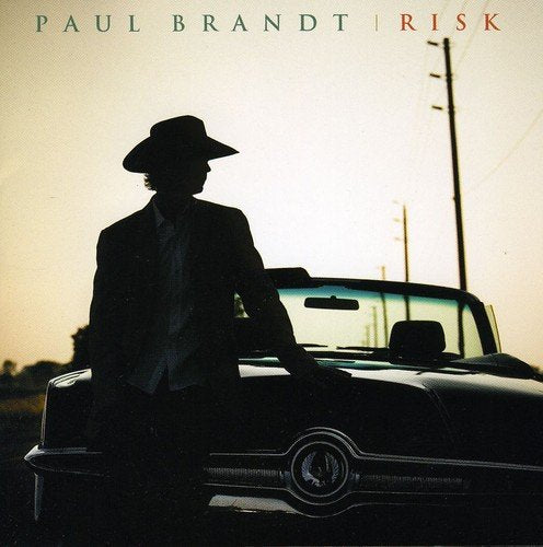 "Album cover featuring a man in a hat leaning on a classic car."