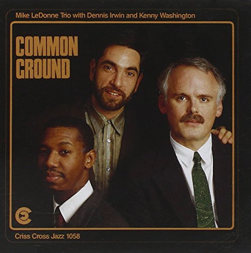 "Album cover with three men in suits against a black background."