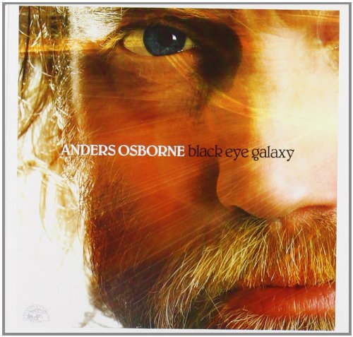 "Album cover with a close-up of a man's face, blue eye, and text."
