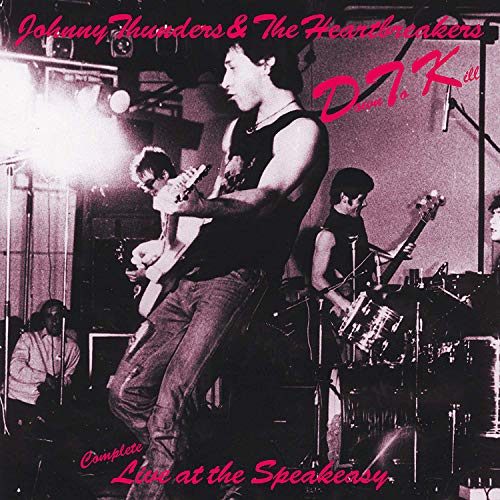 "CD cover with black-and-white photo of band performing on stage, pink text overlay."
