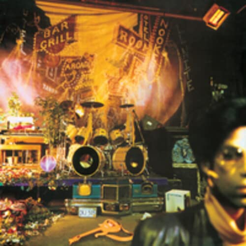 AlbumSL album cover featuring Prince in the foreground and a drum set onstage.
