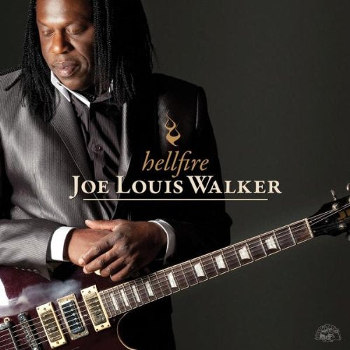 Man in gray suit holding electric guitar, smoke rising, on dark background with album title.