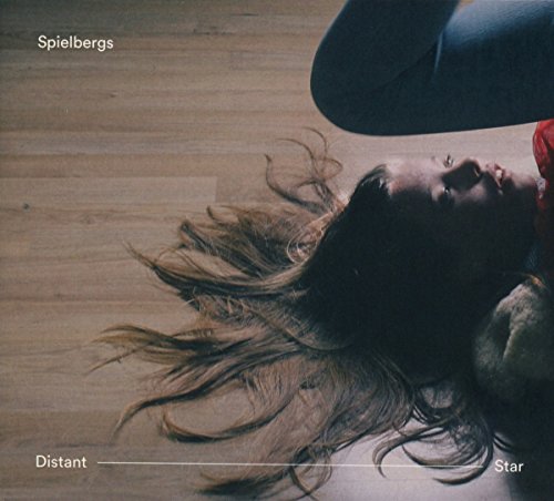 "Album cover featuring a woman lying on a wooden floor, with flowing hair."