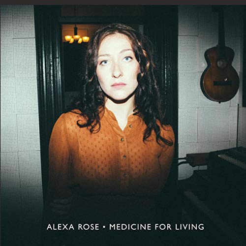 Album cover featuring a woman with curly hair in a dimly lit room with a guitar.