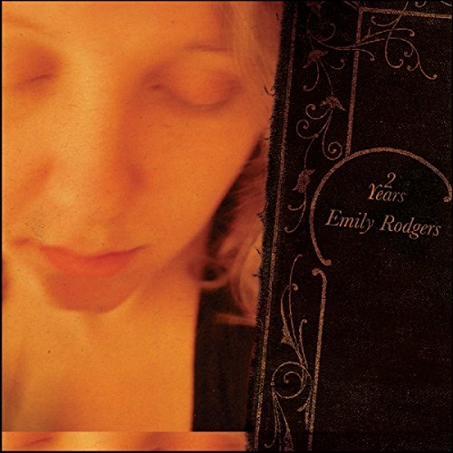 "CD cover with a woman's face and ornate black border."