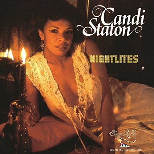 "Album cover featuring a woman in lingerie sitting on a bed with lit candles."
