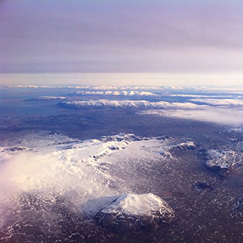 The image depicts a landscape of snow-capped mountains and clouds. For accessibility purposes, a concise alt text could be: "Snow-covered mountains with clouds in the background."