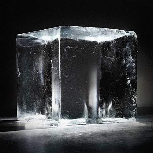 The image depicts a clear, rectangular block with a rough texture and white highlights. Alt text: "Clear, rectangular block with rough texture and white highlights on a dark surface."