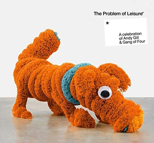 "Orange fluffy dog sculpture with blue collar and googly eye on a gray surface."