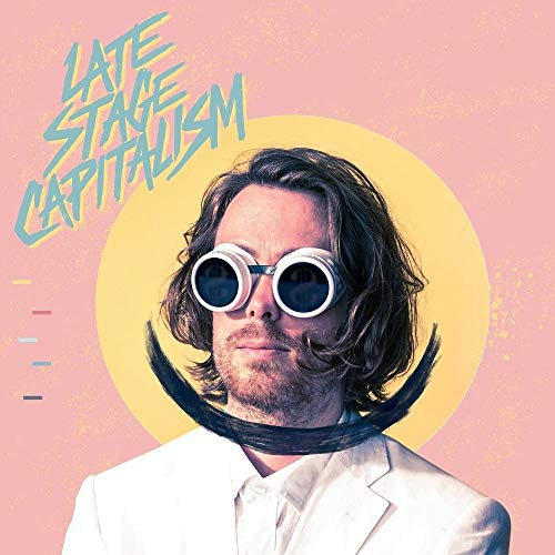 Vinyl album cover featuring a man in a white suit with exaggerated facial features.
