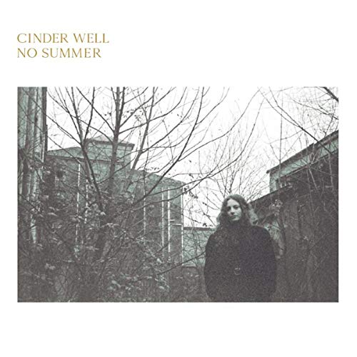 The vinyl album cover features a person standing among bare trees and buildings.