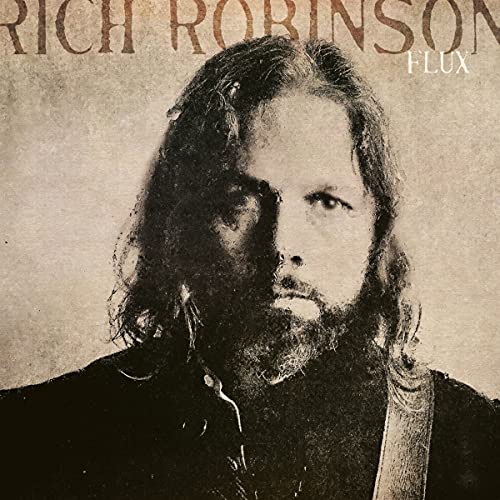 "Album cover with a man having long hair and a beard, sepia-toned."