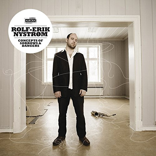 Man in black suit stands in doorway surrounded by white swirling lines, album cover artwork.