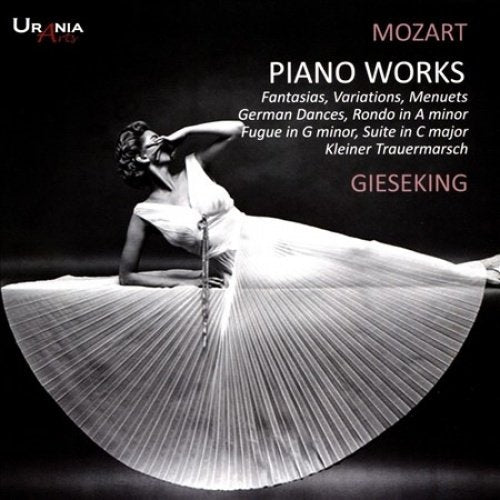 The image depicts a black-and-white photograph of a woman in a flowing white dress, posed in a dramatic dance-like position. The woman is captured mid-movement, with her skirt radiating outward, suggesting she is twirling. The background is dark, and the overall atmosphere is one of elegance and poise. The image is likely an album cover for a classical music recording, as indicated by the text "Mozart Piano Works" and "Gieseking" in the top-right corner.