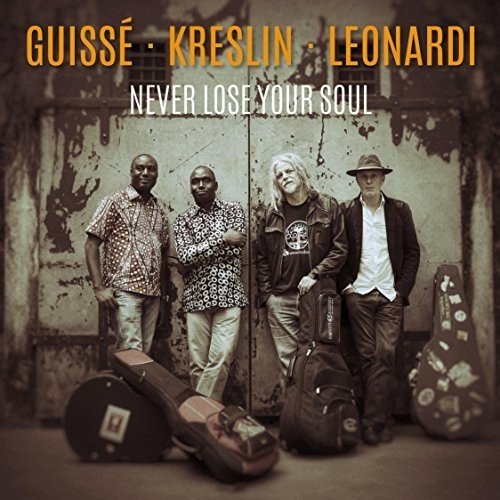 Album cover with four men standing by a distressed wall with guitar cases.