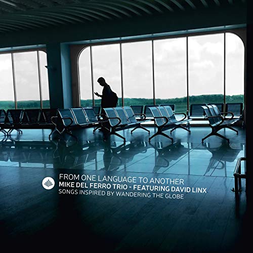 A person stands alone in an airport waiting area with empty chairs and large windows.