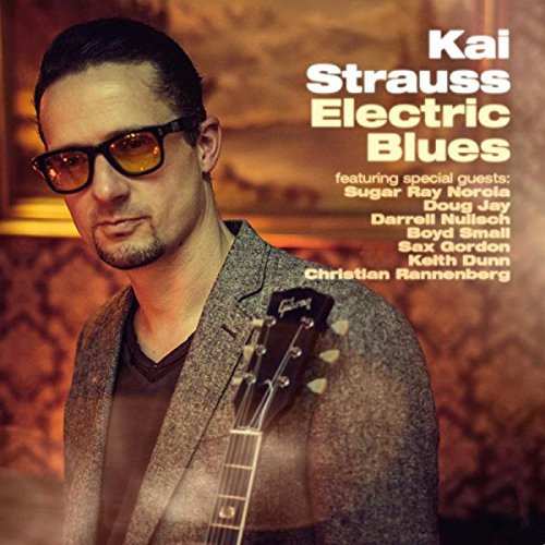 Album cover featuring Kai Strauss with a guitar, wearing sunglasses and a grey jacket.