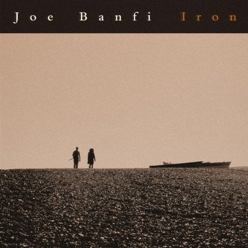 "Album cover with two silhouetted figures walking on a rocky beach, boat in background."