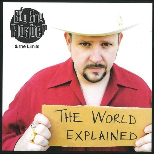 Man in red shirt and white cowboy hat holding a cardboard sign that reads "The World Explained".
