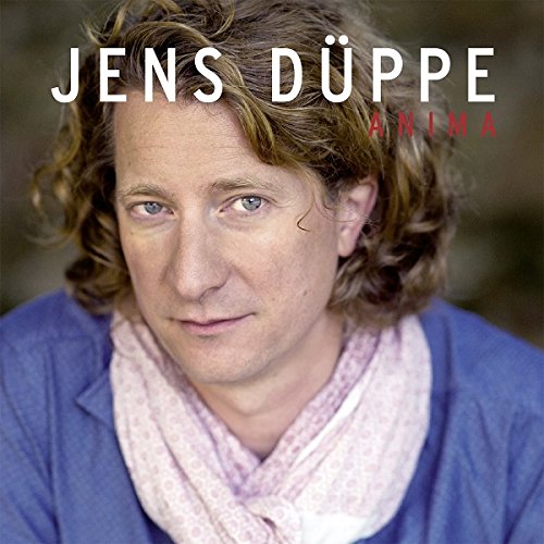 "Album cover featuring a man with curly hair and a blue shirt."