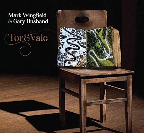 "CD cover featuring a wooden chair with a book on it, against a dark background."