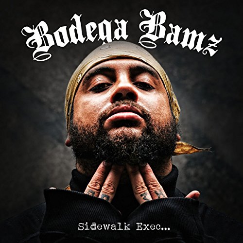 Man with beard and bandana looks up, hands clasped under chin, on album cover.