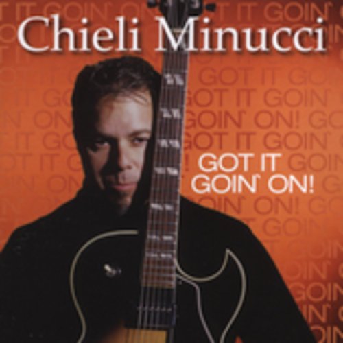 "Album cover featuring a man holding a guitar against an orange background."