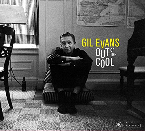 "Album cover with man sitting on floor, piano, and map in the background."