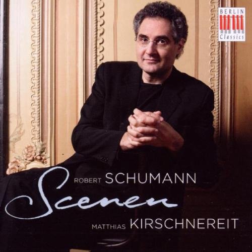 "CD cover with a man in a black suit against ornate beige background."