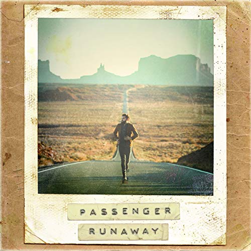 A man runs down a desert road on a vinyl album cover.