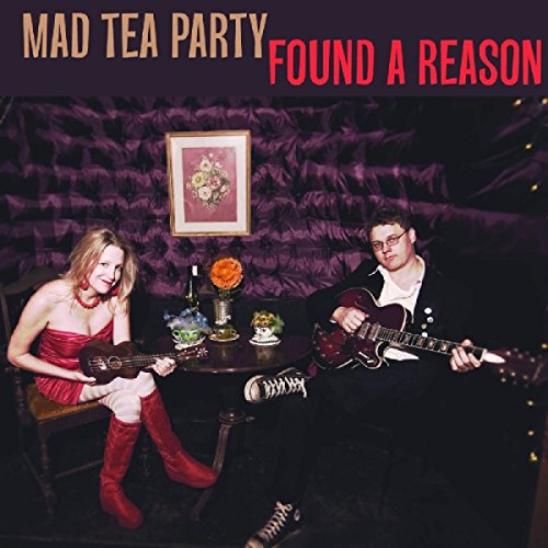 "Album cover featuring a man and woman playing guitars at a table."