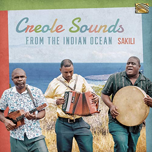 "CD cover featuring three men playing instruments outdoors with ocean in background."
