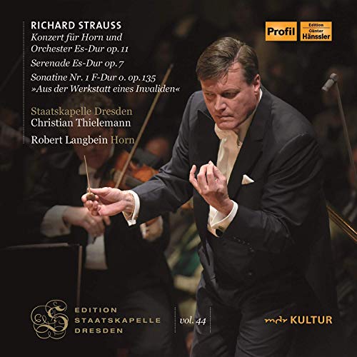 A man in a suit conducts an orchestra, with text on the left.
