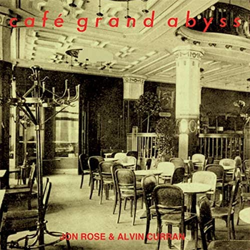 "Album cover with sepia-toned empty café image and red artist and title text."