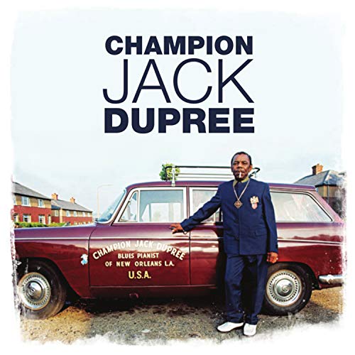 "Album cover featuring a man in a blue suit beside a maroon car."