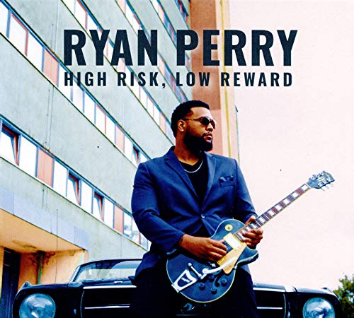 Album cover with man in blue suit holding guitar beside a car.