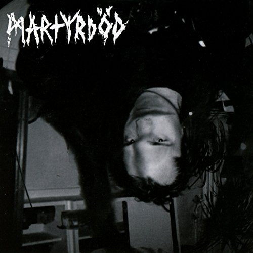"Black and white album cover with a person upside down, wearing a headscarf."
