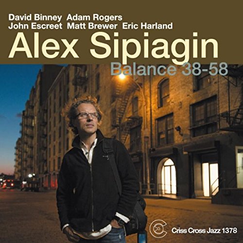 "CD cover featuring a man standing on a city street at dusk."