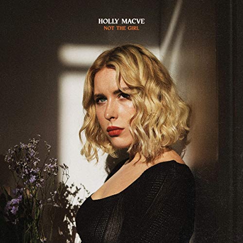 Album cover featuring a blonde woman in a black top holding flowers, with title text above.
