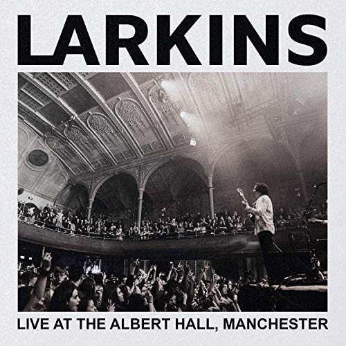 Black and white vinyl album cover with a musician performing at a concert venue.