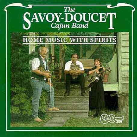 "CD cover featuring three men playing instruments on porch steps, green background."