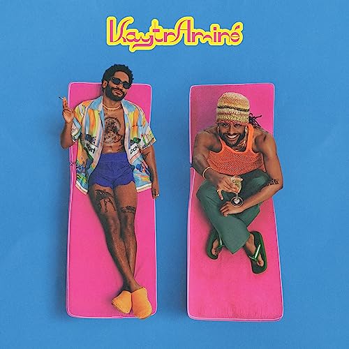 Album cover: two men lounging on pink mats against a blue background.
