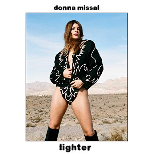 Album cover with a woman in a desert landscape, wearing a black patterned jacket.
