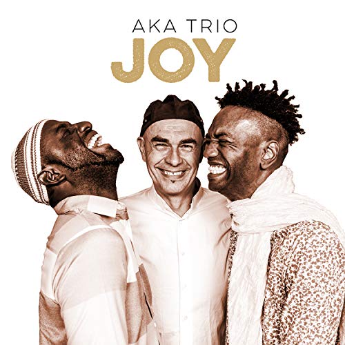 "Album cover featuring three smiling men in white, with 'Aka Trio Joy' text."