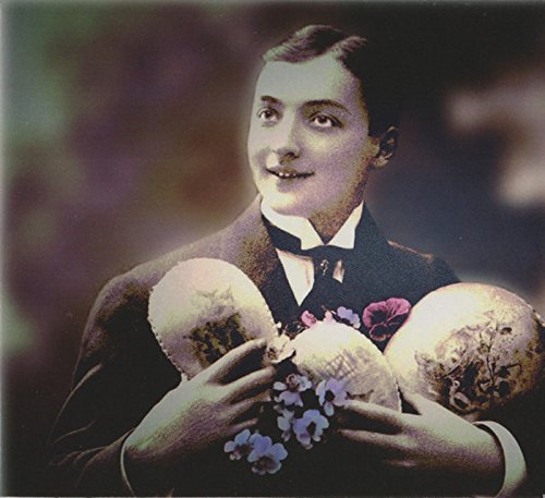 Man in a suit holding three eggs, one with flowers, against a blurred background.