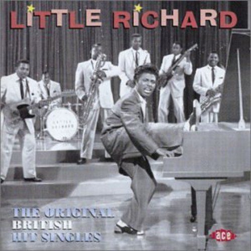 Black and white image of Little Richard performing on stage with band behind him.